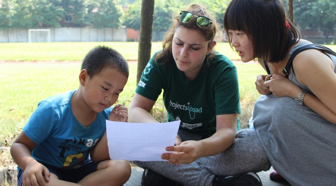 After her Projects Abroad Mandarin Language Course in China, a volunteer teaches English at a local school. After learning Mandarin in China, a student volunteers at a local school, teaching English.